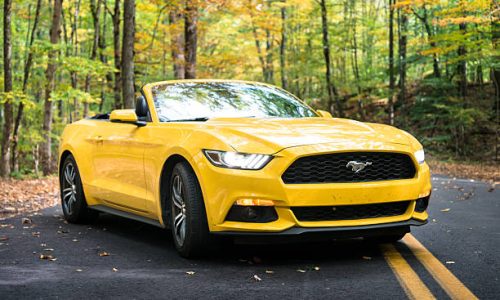 Ford-Mustang-Yellow East Lyme, Connecticut, USA - October 13, 2016: View of a yellow Ford Mustang GT convertible 2016 version parked on the middle of the road of the Nehantic State Forest in Conncticut. The forest is located in the south of connecticut. Ford Mustang is a sport coupe made by Ford.